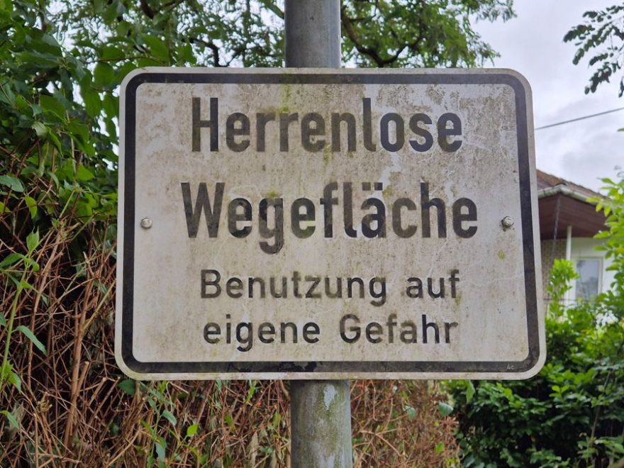 Straßenschild "Herrenlose Wegefläche Benutzung auf eigene Gefahr"